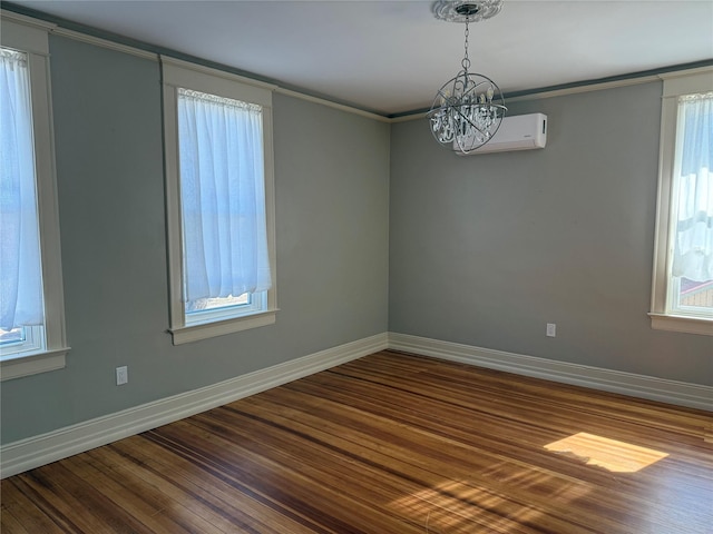 unfurnished room with a notable chandelier, hardwood / wood-style flooring, ornamental molding, and a wall mounted air conditioner