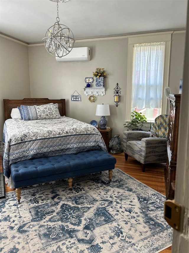 bedroom with crown molding, an inviting chandelier, hardwood / wood-style floors, and a wall mounted air conditioner