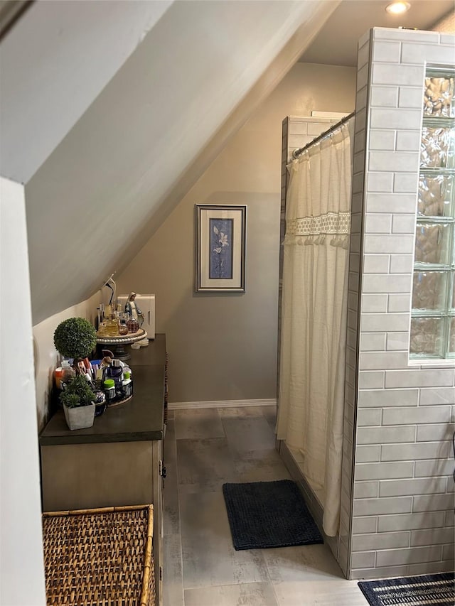 bathroom featuring lofted ceiling