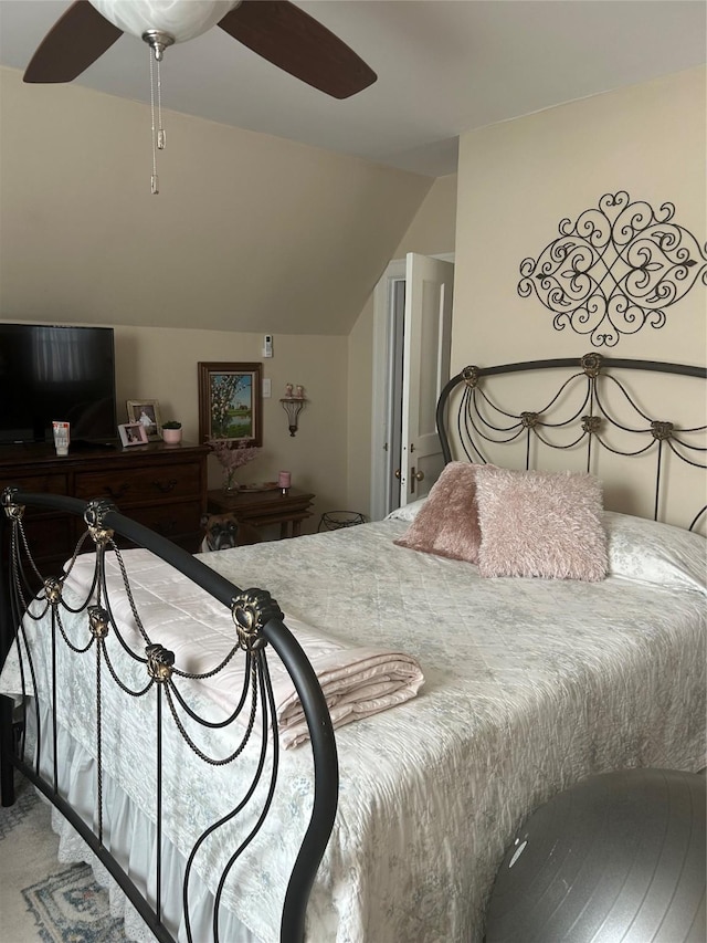 bedroom with ceiling fan, vaulted ceiling, and carpet flooring