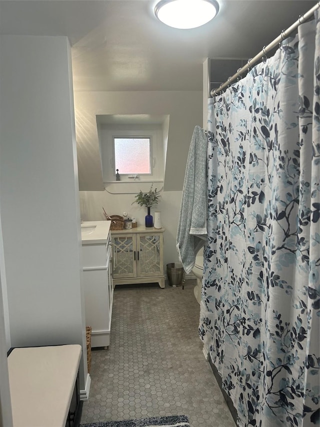 bathroom with toilet, vanity, and a shower with curtain