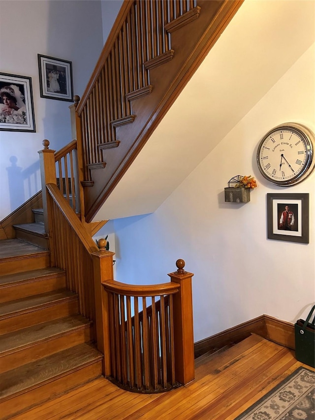 staircase with hardwood / wood-style floors