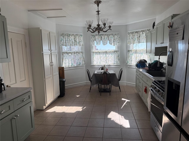 kitchen featuring decorative light fixtures, appliances with stainless steel finishes, light tile patterned flooring, and a chandelier