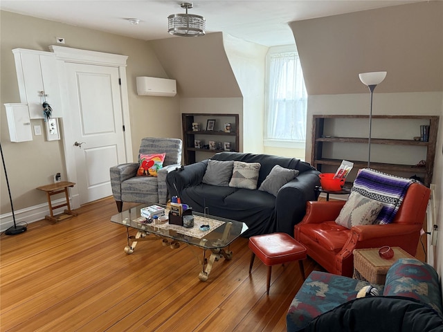 living room featuring light wood-type flooring, an inviting chandelier, and a wall mounted air conditioner