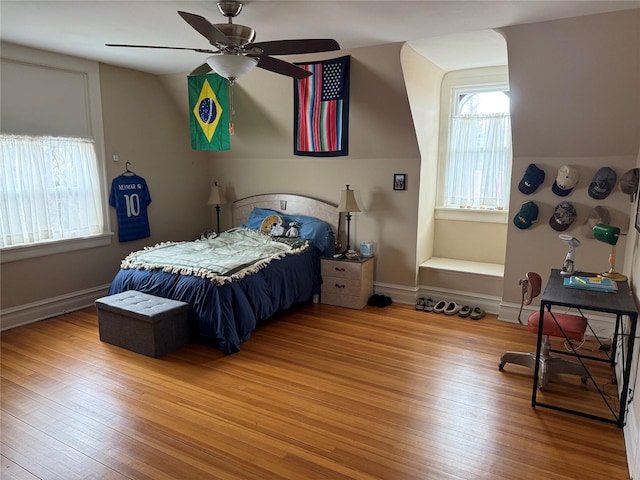 bedroom with ceiling fan, vaulted ceiling, and light hardwood / wood-style flooring