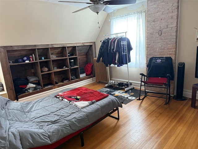 bedroom featuring ceiling fan, hardwood / wood-style flooring, and lofted ceiling