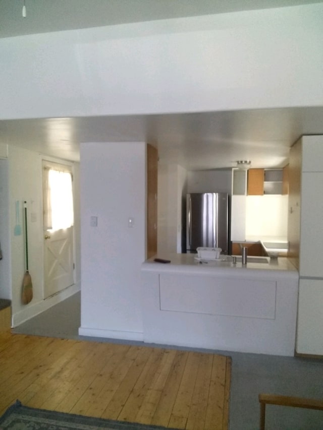 kitchen featuring sink, hardwood / wood-style floors, and stainless steel fridge