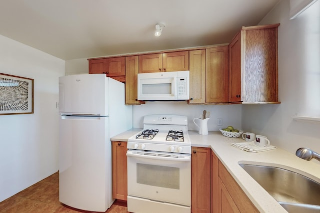 kitchen with sink, white appliances, and light tile patterned flooring