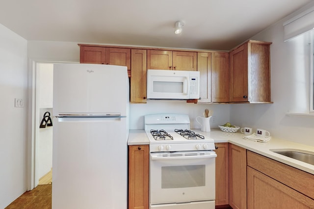 kitchen with sink, white appliances, and light tile patterned floors