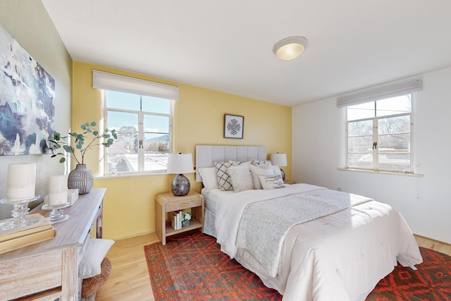 bedroom with multiple windows and hardwood / wood-style flooring