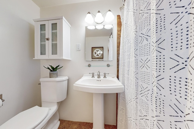 bathroom with curtained shower, toilet, and sink