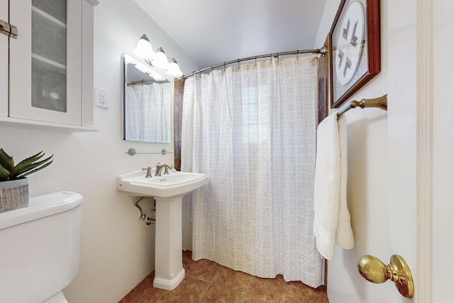 bathroom with toilet, tile patterned floors, curtained shower, and sink