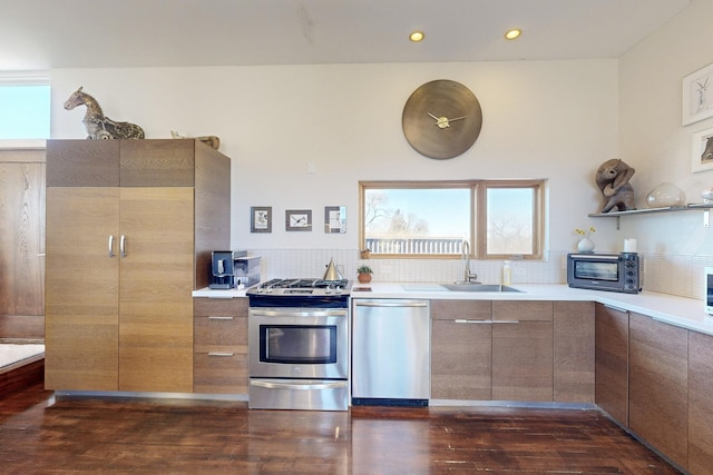 kitchen featuring dark hardwood / wood-style floors, stainless steel appliances, backsplash, and sink