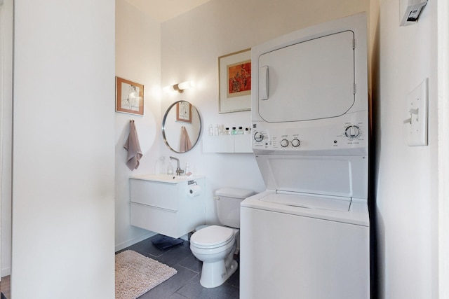 bathroom with toilet, stacked washer / drying machine, tile patterned floors, and vanity