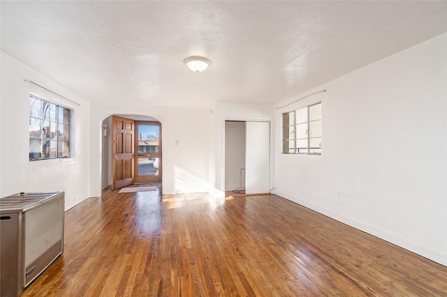 empty room featuring hardwood / wood-style flooring and heating unit