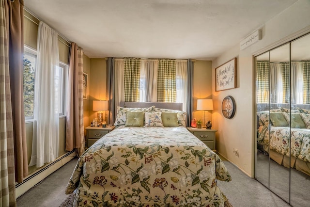 bedroom with carpet flooring, a baseboard heating unit, and a closet