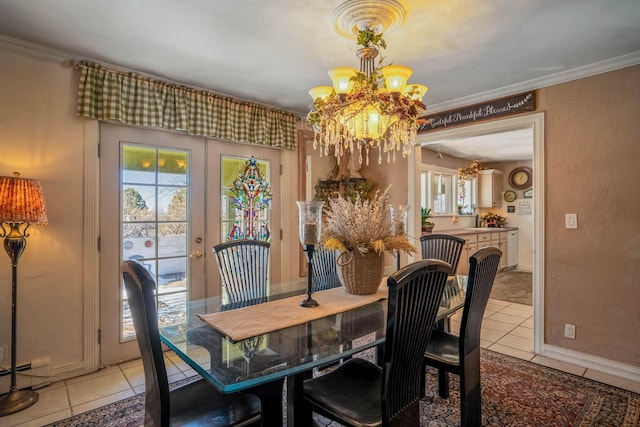 tiled dining space with crown molding, a notable chandelier, and french doors