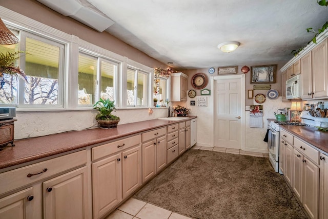 kitchen with sink, white appliances, and light tile patterned flooring