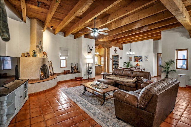 tiled living room with beamed ceiling, ceiling fan with notable chandelier, ornate columns, and wooden ceiling