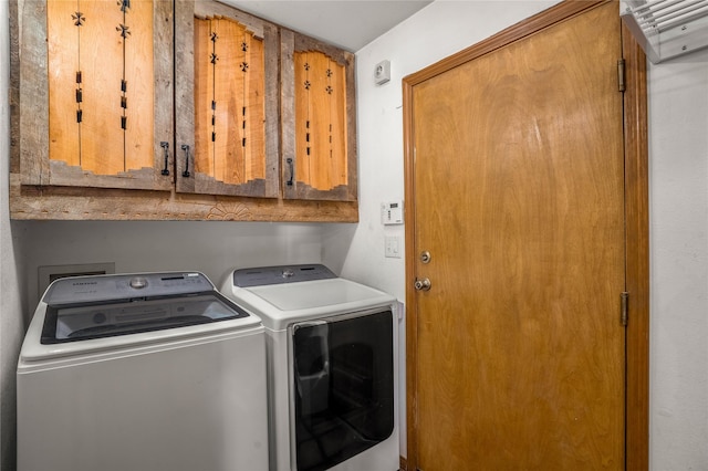 laundry room with washer and dryer and cabinets