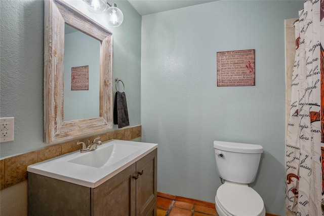 bathroom featuring toilet, tile patterned floors, vanity, and curtained shower