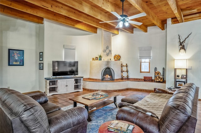 tiled living room with ceiling fan, beamed ceiling, and wood ceiling