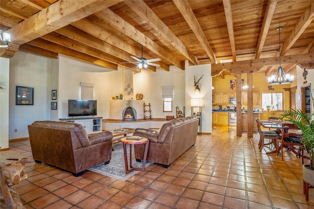 living room with ceiling fan, tile patterned flooring, beam ceiling, a high ceiling, and wooden ceiling