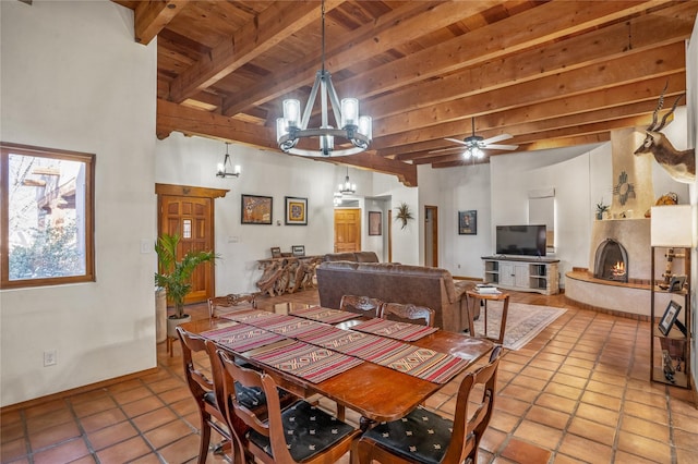 tiled dining space with wood ceiling, ceiling fan with notable chandelier, and beamed ceiling