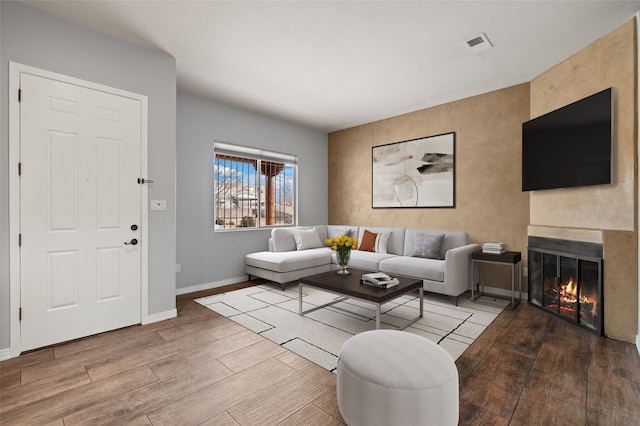 living room with light hardwood / wood-style flooring and a large fireplace