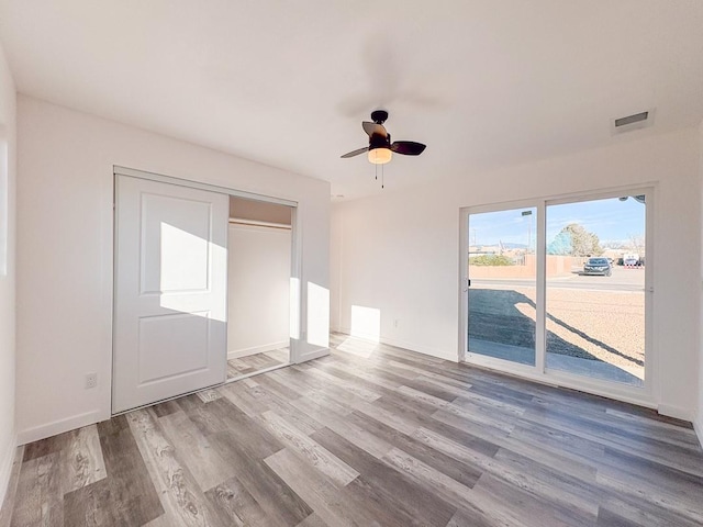 interior space featuring ceiling fan, access to exterior, a closet, and light hardwood / wood-style flooring