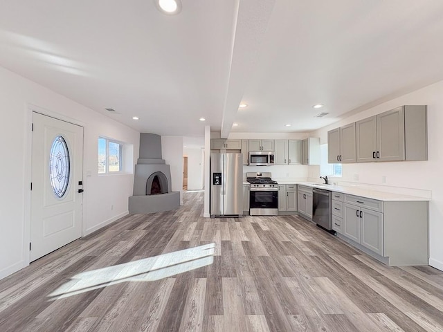 kitchen featuring sink, gray cabinets, light hardwood / wood-style floors, and appliances with stainless steel finishes