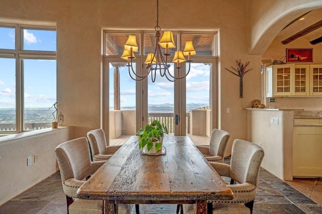 dining area with a notable chandelier and beam ceiling