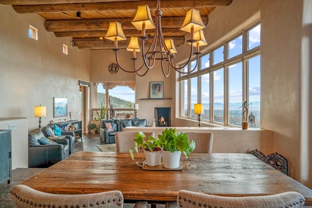 dining area with beamed ceiling, an inviting chandelier, a wealth of natural light, and wooden ceiling