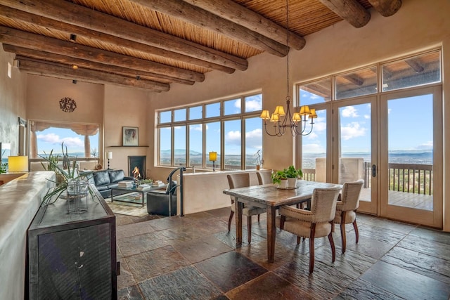 dining room featuring a notable chandelier, a water view, beamed ceiling, and wooden ceiling