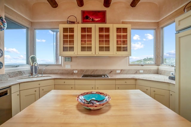 kitchen with stainless steel dishwasher, brick ceiling, sink, cream cabinetry, and black electric cooktop