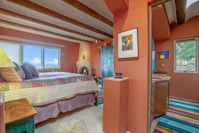 bedroom with sink, multiple windows, light colored carpet, and beam ceiling