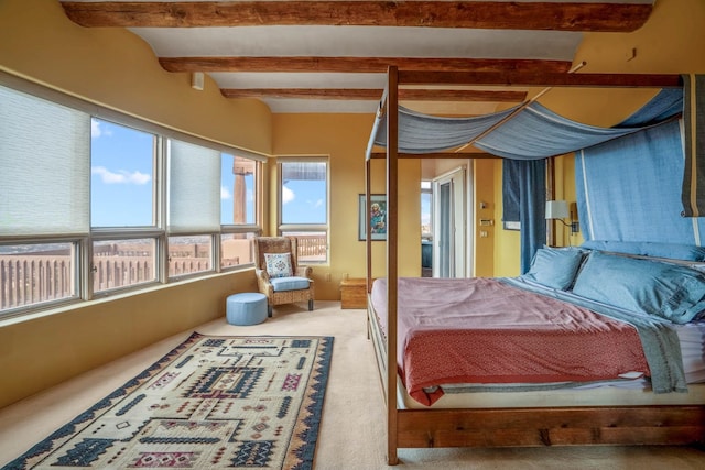 carpeted bedroom with beam ceiling