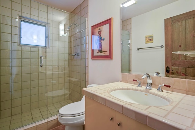 bathroom featuring vanity, toilet, and a shower with shower door