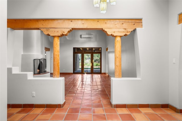 interior space featuring french doors, a wall mounted air conditioner, and ornate columns