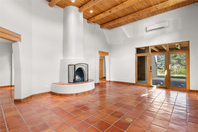 unfurnished living room with a towering ceiling, a large fireplace, a wall mounted AC, wooden ceiling, and beam ceiling