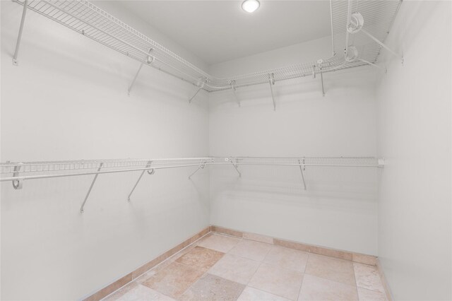 interior space with ceiling fan, tile patterned floors, and a wall unit AC