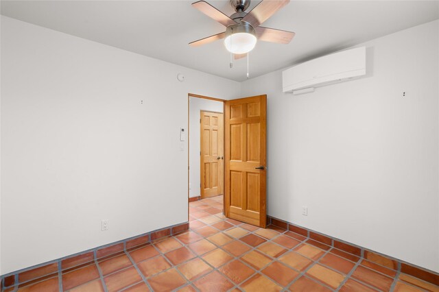 empty room featuring a wall unit AC, tile patterned floors, and ceiling fan