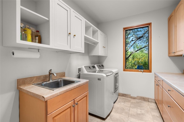 laundry area featuring cabinets, washing machine and dryer, sink, and light tile patterned flooring