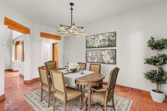 tiled dining space with an inviting chandelier