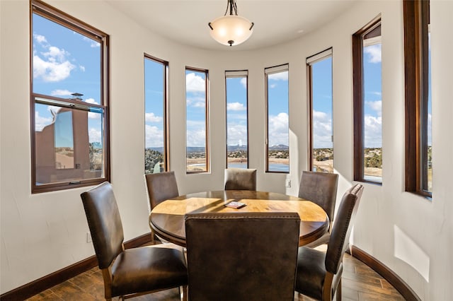 dining area with a water view and dark hardwood / wood-style flooring