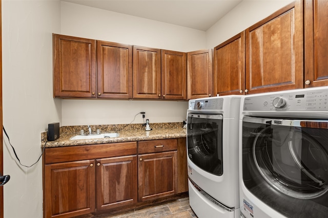 washroom with sink, cabinets, and independent washer and dryer