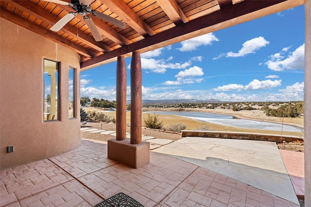 view of patio featuring ceiling fan and a water view