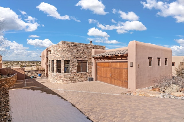 pueblo-style house featuring a garage