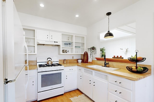 kitchen featuring pendant lighting, light hardwood / wood-style flooring, sink, white cabinets, and white appliances