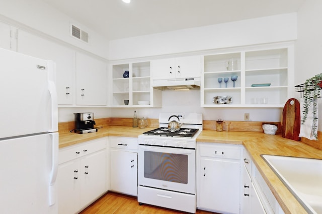 kitchen with sink, white appliances, white cabinets, and light hardwood / wood-style floors